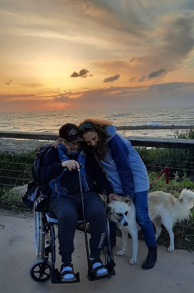 מצילים כלבים, מתנדבת עם קשיש והכלב שלו. המתנדבים עוזרים לבעלי הכלבים.